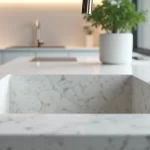 Pia de granito branco Itaúnas impecavelmente limpa com bancada brilhante e decoração moderna ao fundo