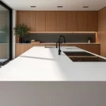 Cozinha residencial sofisticada com ilha de Corian branco e bancada integrada